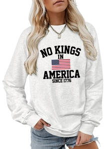 Detail of No Kings In America 1776 print and US flag on grey crewneck sweatshirt