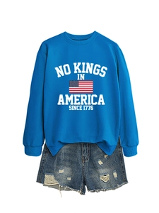 Detail of blue crewneck sweatshirt with 1776 print and distressed denim shorts