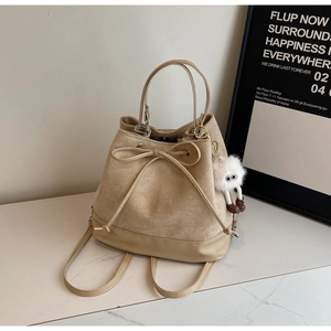 Detail of drawstring bucket bag with leather bow and cute white plush doll keychain