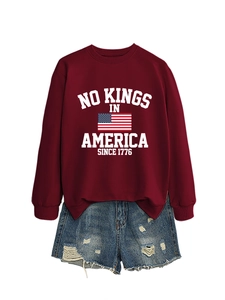 Flat lay of a burgundy sweatshirt with American flag print and distressed denim shorts