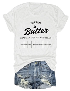 Flat lay of salted butter graphic t-shirt paired with distressed blue denim shorts