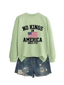 Flat lay of green sweatshirt with 1776 print and distressed denim shorts set