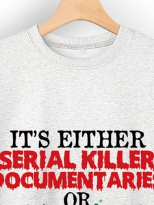 Dettaglio felpa grigia con scritta Serial Killer Documentaries e fiocco di neve verde