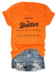 Flat lay of an orange cotton T-shirt featuring a Salted Butter graphic and denim shorts