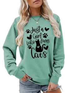 Detail of mint green sweatshirt featuring black Just a Girl Who Loves Cats graphic print
