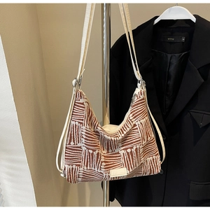 Detail of striped canvas tote with brown geometric patterns and FASHION leather tag