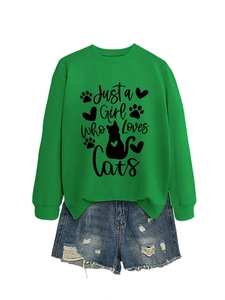 Detailed flat lay of green sweatshirt with 'Just a Girl Who Loves Cats' print and denim shorts