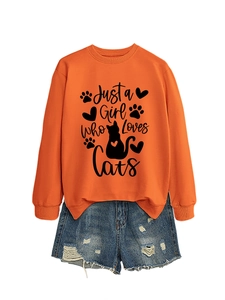Detail of orange sweatshirt with Just a Girl Who Loves Cats print and ripped denim shorts