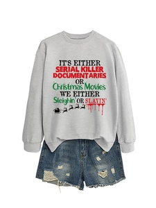 Dettaglio in piano di una felpa grigio chiaro con slogan grafici e pantaloncini di jeans
