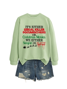 Dettaglio della felpa verde chiaro con stampa grafica e pantaloncini in denim strappati
