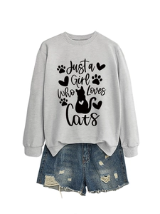 Flat lay of light grey cat slogan sweatshirt paired with distressed denim shorts