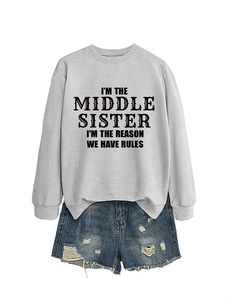 Détail du sweat-shirt gris avec texte 'I'M THE MIDDLE SISTER' et un short en jean