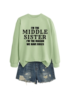 Mise à plat d'un sweat vert menthe avec slogan et d'un short en jean bleu délavé et déchiré