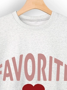 Detail of grey crewneck sweatshirt with pink Favorite text and red heart print on hanger