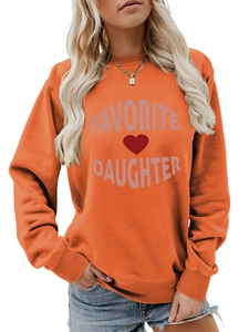 Detail of orange crewneck sweatshirt featuring Favorite Daughter print and red heart design