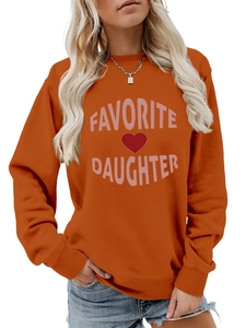 Detail of bright orange sweatshirt featuring pink Favorite Daughter print and heart