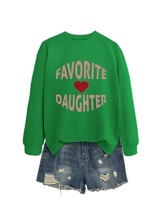 Flat lay of a green crewneck sweatshirt with pink Favorite Daughter text and denim shorts