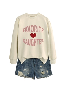 Detail of white sweatshirt with pink favorite daughter text and blue distressed denim shorts