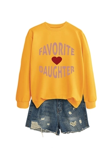 Flat lay of yellow Favorite Daughter sweatshirt with distressed denim shorts