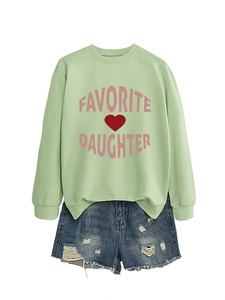 Detail of mint green sweatshirt with pink Favorite Daughter text and ripped denim shorts