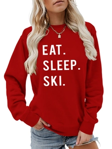 Close-up of red crew neck sweatshirt with white Eat Sleep Ski slogan print and ribbing