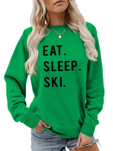 Detail of Eat Sleep Ski bold black lettering on a green casual crewneck sweatshirt