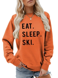 Detail of ribbed cuffs and EAT SLEEP SKI print on women's orange long sleeve sweatshirt