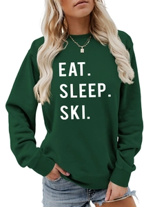 Close-up of Eat Sleep Ski slogan printed on dark green crewneck sweatshirt fabric