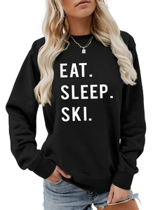 Close-up of the ribbed cuffs and white 'EAT. SLEEP. SKI.' lettering on a black sweatshirt