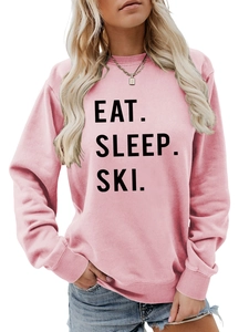 Close-up of Eat Sleep Ski slogan print on soft pink crewneck sweatshirt for women