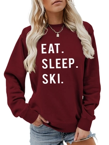 Detail of Eat Sleep Ski white bold lettering on a burgundy crewneck sweatshirt