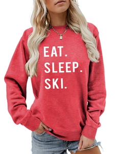 Close-up of Eat Sleep Ski white bold text print on a vibrant red crewneck sweatshirt