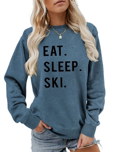 Detail of Eat Sleep Ski slogan print on soft denim blue long sleeve sweatshirt