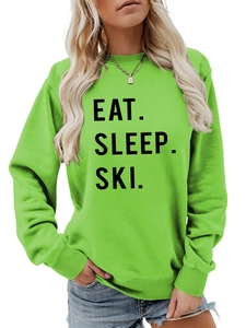 Detail of neon green crewneck sweatshirt with black Eat Sleep Ski printed slogan