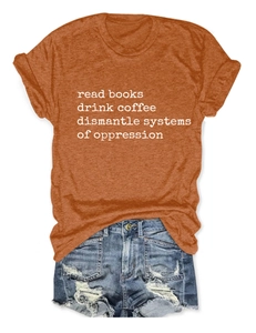 Burnt orange slogan t-shirt tucked into distressed denim shorts on white background