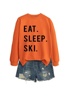 Detail of Eat Sleep Ski orange sweatshirt with distressed denim shorts outfit set