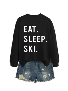Detail of Eat Sleep Ski black sweatshirt paired with ripped denim shorts set