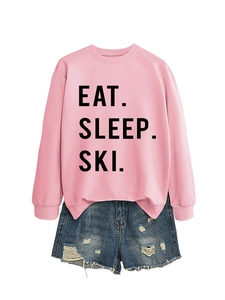 Detail of pink sweatshirt with Eat Sleep Ski print paired with blue denim shorts