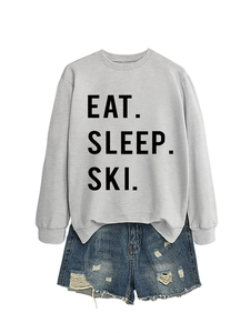 Detail of Eat Sleep Ski slogan print on light grey sweatshirt with denim shorts set
