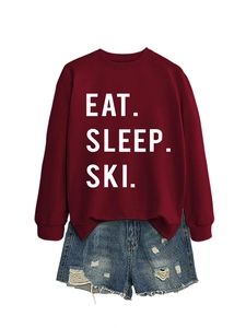 Detail of burgundy Eat Sleep Ski printed sweatshirt paired with distressed denim shorts