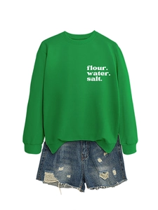 Felpa verde a maniche lunghe con scritta bianca e pantaloncini di jeans chiari con strappi