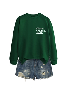 Dettaglio della felpa verde scuro con stampa bianca e pantaloncini di jeans logori