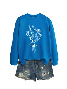 Détail du sweat bleu à col rond avec imprimé floral Oma et short en jean bleu déchiré