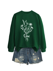 Détail du sweat-shirt vert foncé avec imprimé floral Oma et short en jean déchiré