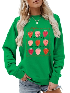 Close-up of strawberry print and Teaching Is My Jam slogan on green sweatshirt