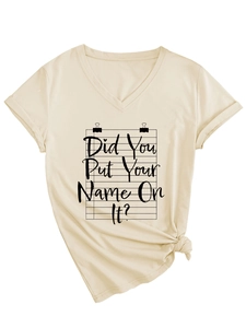 Detail of V-neck beige t-shirt featuring paper graphic print and side knot hem design