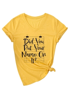 Detail of V-neck ginger yellow t-shirt with knotted hem and artistic text print