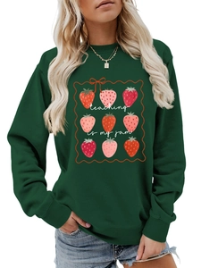 Detail of strawberry grid print and teaching is my jam lettering on green sweatshirt