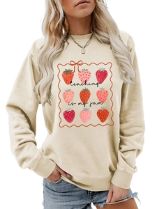 Detail of Teaching is My Jam text and strawberry print on beige crewneck sweatshirt