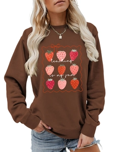Detail of the strawberry print and teaching is my jam lettering on the brown sweatshirt